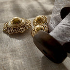 The "Art of Being a Lady," a vintage 1960s Trifari demi-parure, featuring a sculptural gold hat brooch and a pair of matching clip-on earrings.