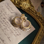 A macro shot detailing the intricate, lace-like filigree craftsmanship of the Trifari earrings, a hallmark of the brand's high-quality production.