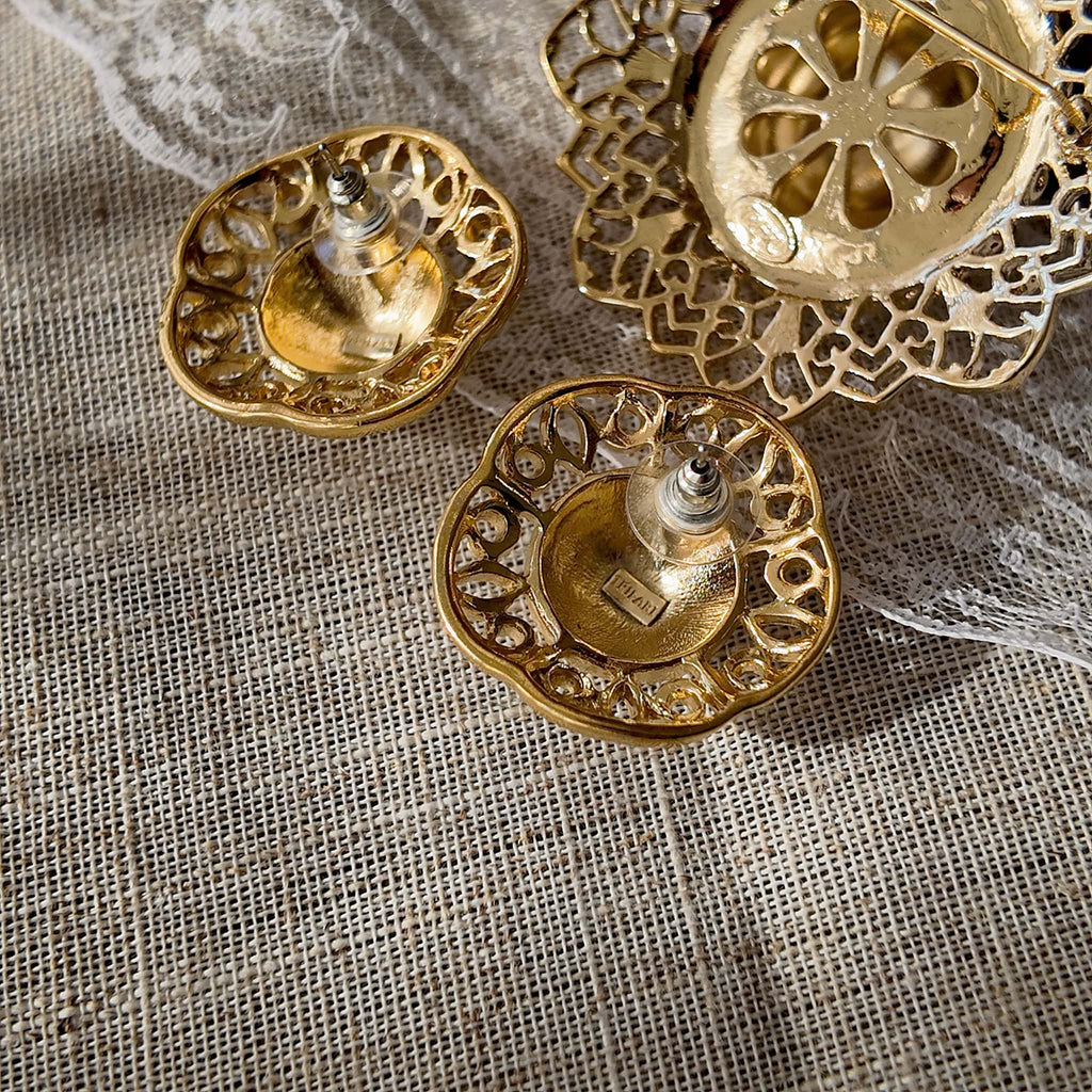 A macro shot detailing the intricate, lace-like filigree craftsmanship on the brim of the Trifari hat brooch, a hallmark of the brand's 1960s high-quality production.