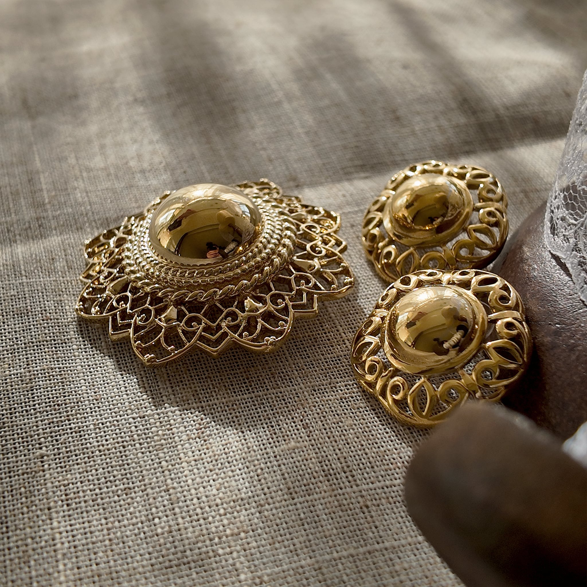 A detailed view of the matching Trifari hat earrings, echoing the brooch's design with a lustrous, gold-plated finish and whimsical sculptural form.