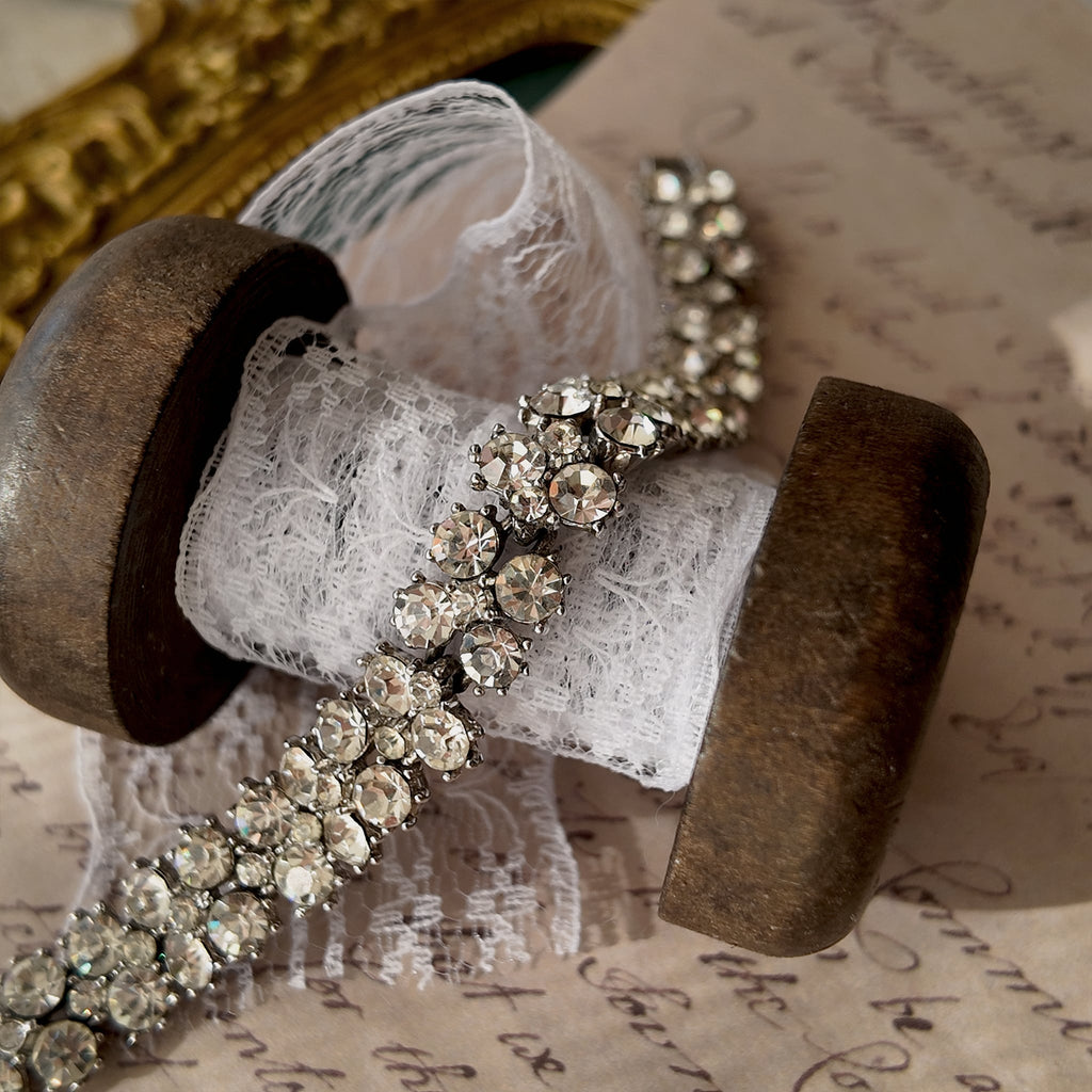 An angled view of the three-row rhinestone bracelet, highlighting the fluid movement of the silver-tone links and the exceptional fire of the crystals.
