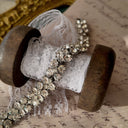 An angled view of the three-row rhinestone bracelet, highlighting the fluid movement of the silver-tone links and the exceptional fire of the crystals.