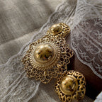 A close-up of the Trifari figural hat brooch, showcasing the dimensional design with its smooth, domed crown and intricate, openwork filigree brim.