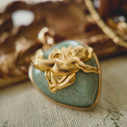 Side profile of the heart-shaped pendant showing the thickness of the stone and brass construction.