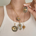 A woman wearing the Labradorite and dove pendant, showcasing its elegant size and its identity as a powerful symbol of hope and new beginnings.