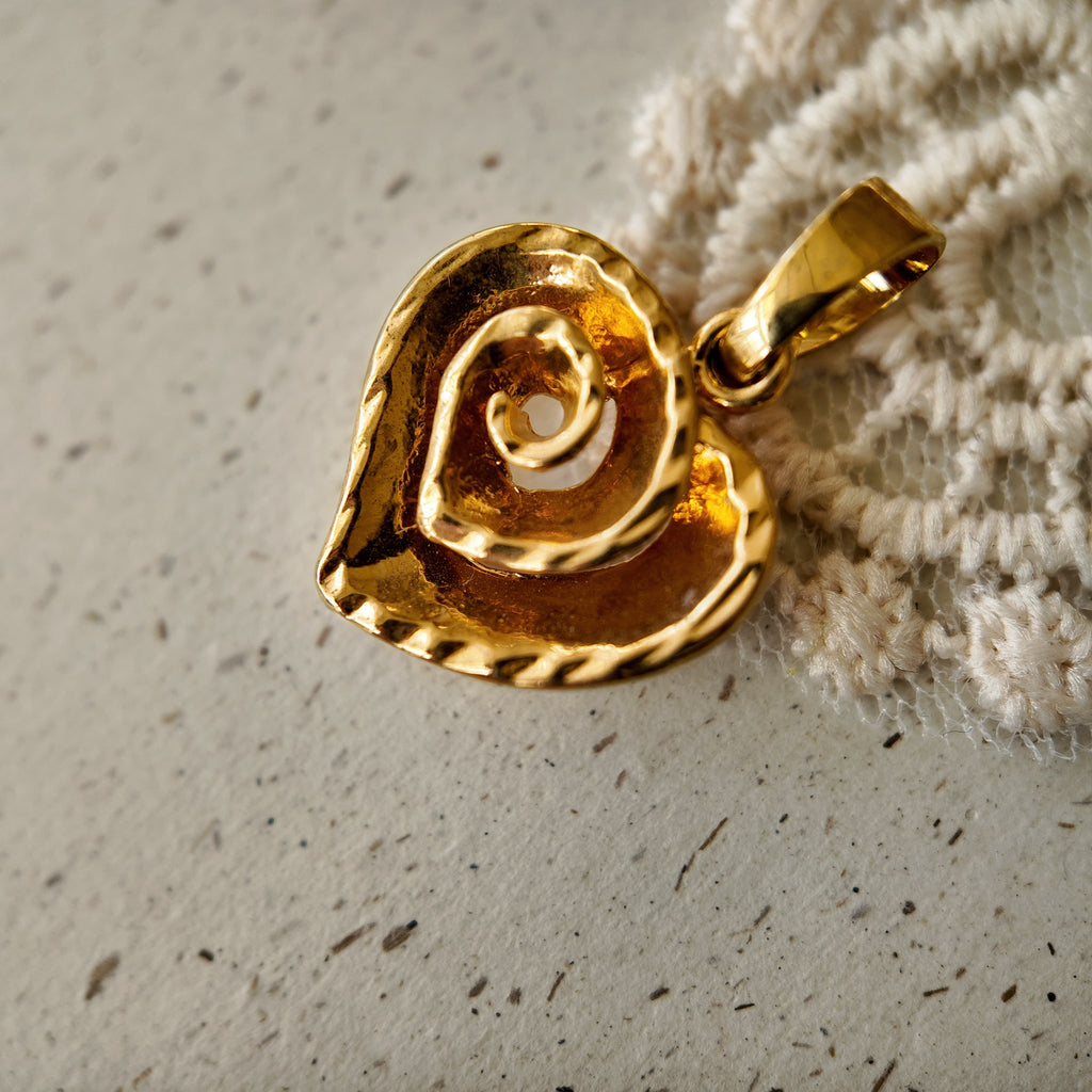 Close-up macro shot of the rich, buttery texture of the heavy real gold plating on The Character Arc's upcycled vintage pendant.