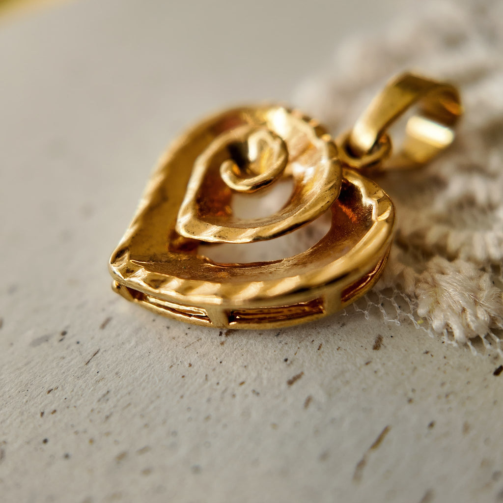 Artisan-made "Sunset Vortex" gold necklace styled in a warm, sun-drenched setting to evoke a sustainable, eco-conscious aesthetic.