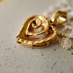 Artisan-made "Sunset Vortex" gold necklace styled in a warm, sun-drenched setting to evoke a sustainable, eco-conscious aesthetic.