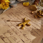 An angled view of the modernist gold brooch, highlighting the charming, ambiguous motion of the Sisyphus-like figure—is he dancing or struggling?