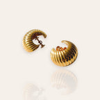 The "SoHo Loft," a pair of vintage 1970s statement hoop earrings by Vendôme, featuring a substantial, sculptural "croissant" design in a soft, lustrous gold tone.