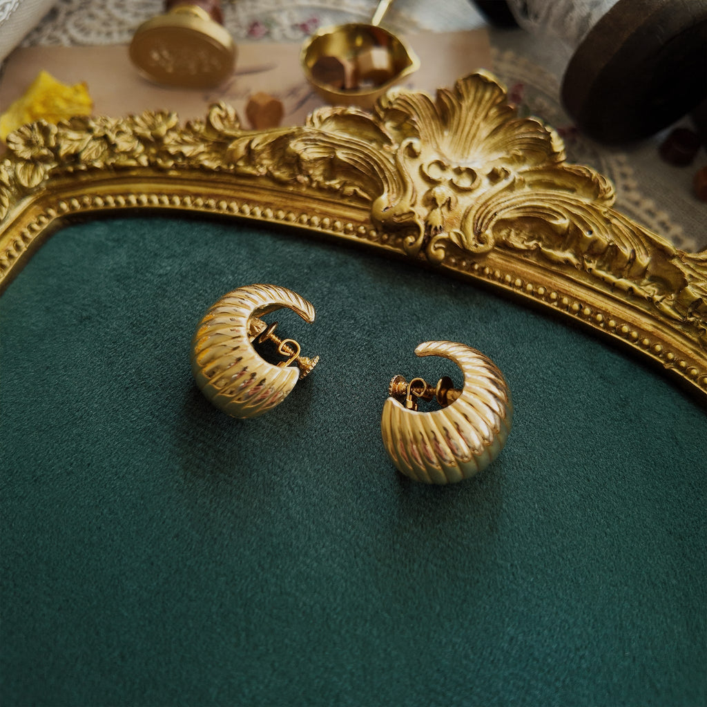 The "SoHo Loft," a pair of vintage 1970s statement hoop earrings by Vendôme, featuring a substantial, sculptural "croissant" design in a soft, lustrous gold tone.