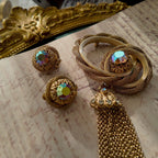 A detailed view of the matching Vendôme earrings, highlighting the woven gold texture and the large, central Aurora Borealis crystal with its otherworldly fire.