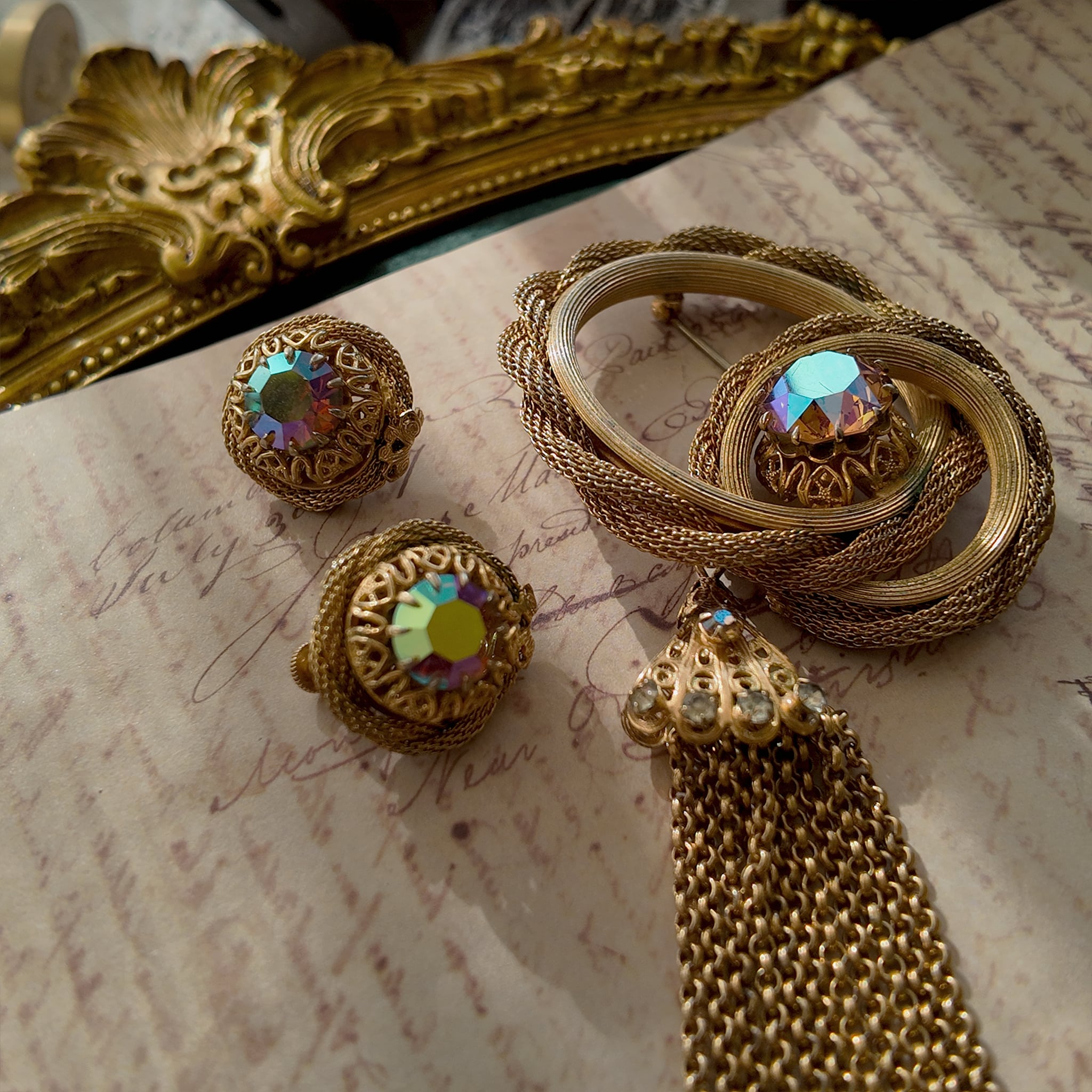 A detailed view of the matching Vendôme earrings, highlighting the woven gold texture and the large, central Aurora Borealis crystal with its otherworldly fire.