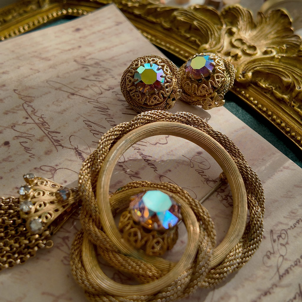 A detailed view of the matching Vendôme earrings, highlighting the woven gold texture and the large, central Aurora Borealis crystal with its otherworldly fire.