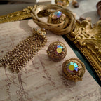 A detailed view of the matching Vendôme earrings, highlighting the woven gold texture and the large, central Aurora Borealis crystal with its otherworldly fire.