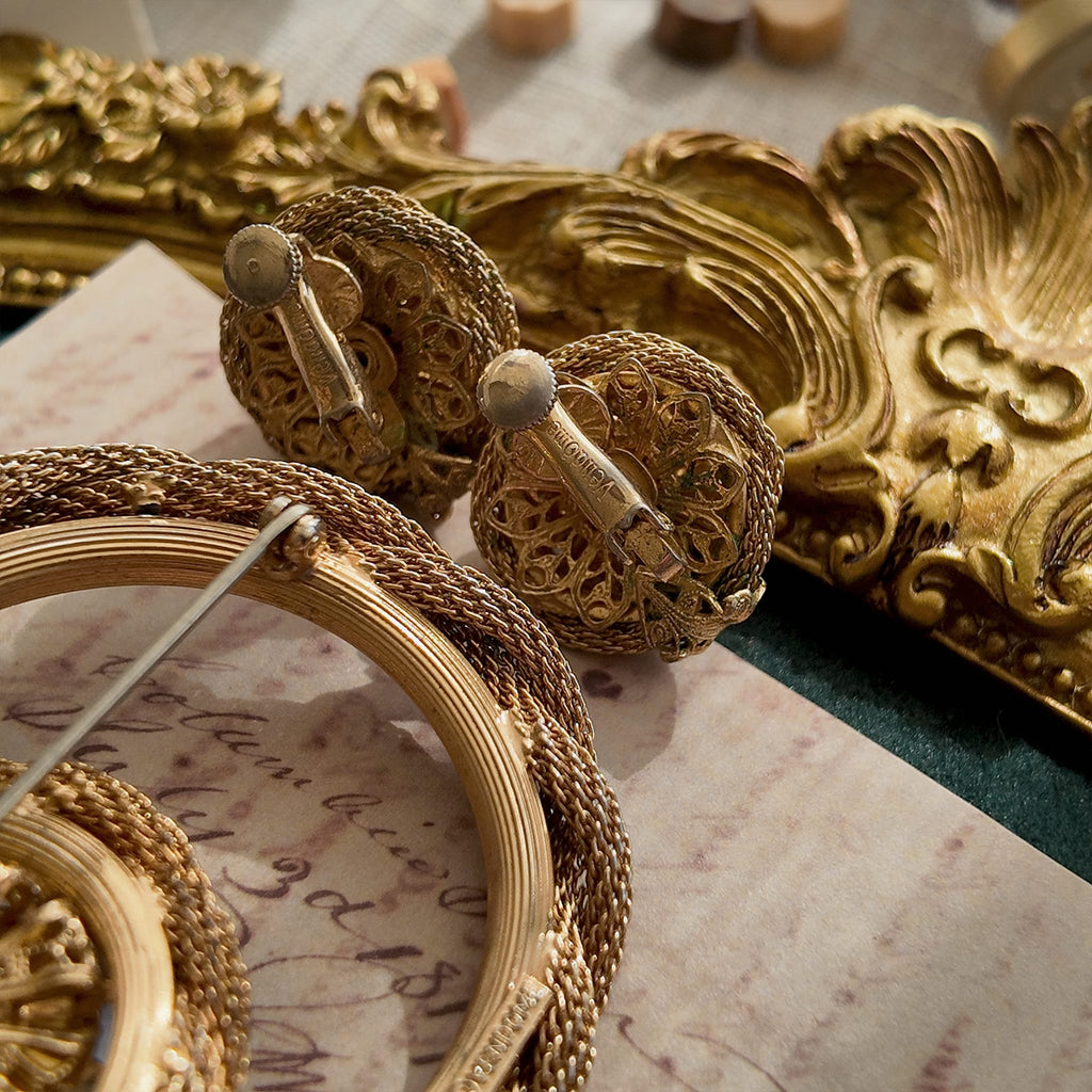 A detailed photo of the back of the Vendôme earrings, clearly showing areas of tarnishing and some green oxidation (verdigris), defining its "historical artifact" condition.