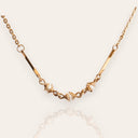 The "Quiet Rebel," a vintage Avon necklace in a Brutalist style, featuring three faux pearls intentionally entangled and caged by textured, bronze-tone wires.