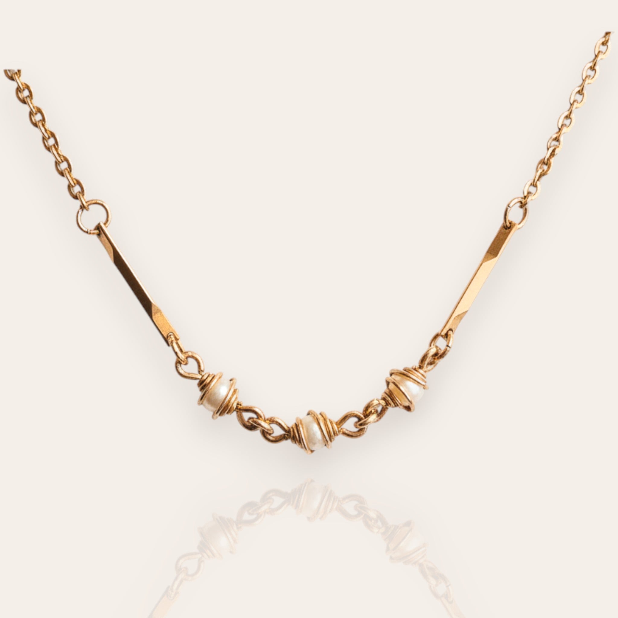 The "Quiet Rebel," a vintage Avon necklace in a Brutalist style, featuring three faux pearls intentionally entangled and caged by textured, bronze-tone wires.