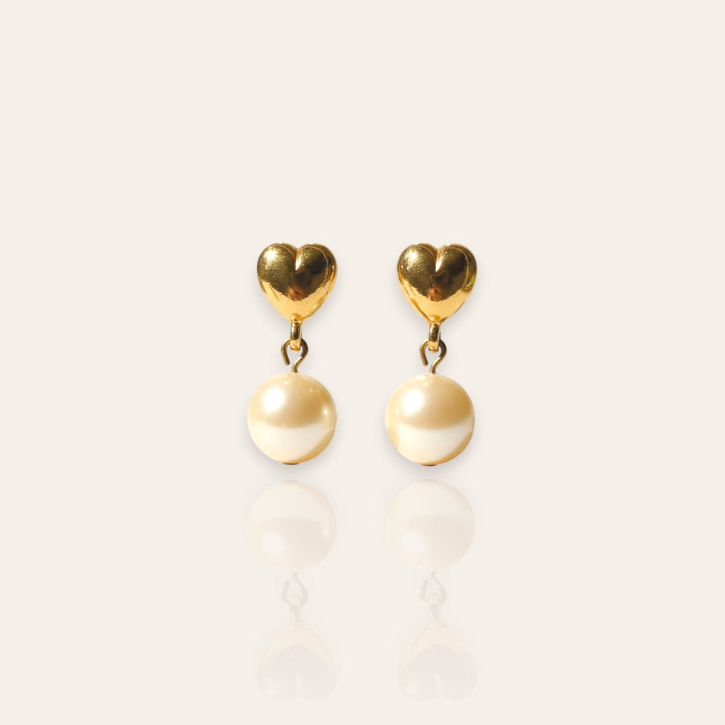 The "Daily Dose of Darling," a pair of vintage Avon dangle earrings, featuring a polished gold-tone heart stud with a single, dangling faux pearl.