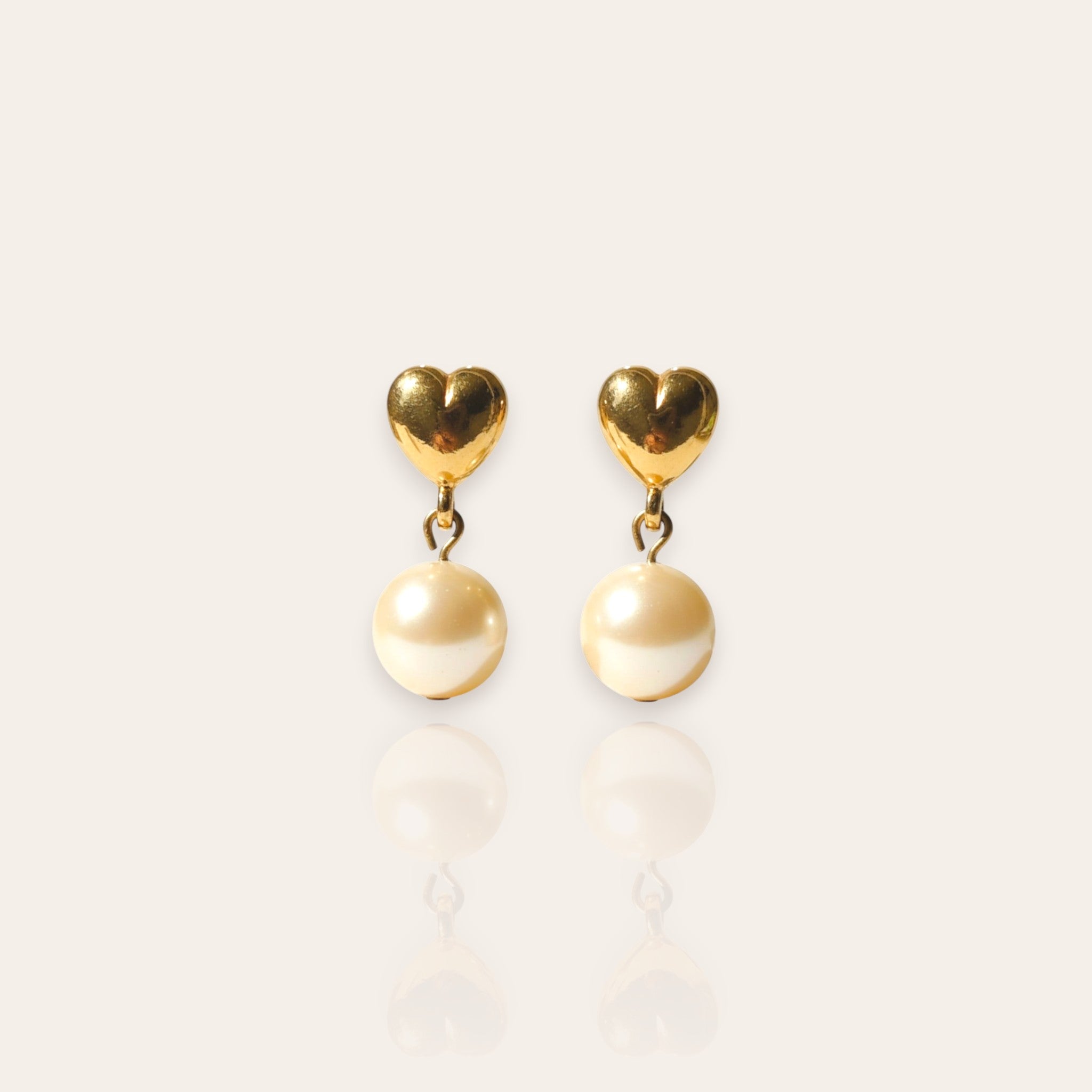 The "Daily Dose of Darling," a pair of vintage Avon dangle earrings, featuring a polished gold-tone heart stud with a single, dangling faux pearl.