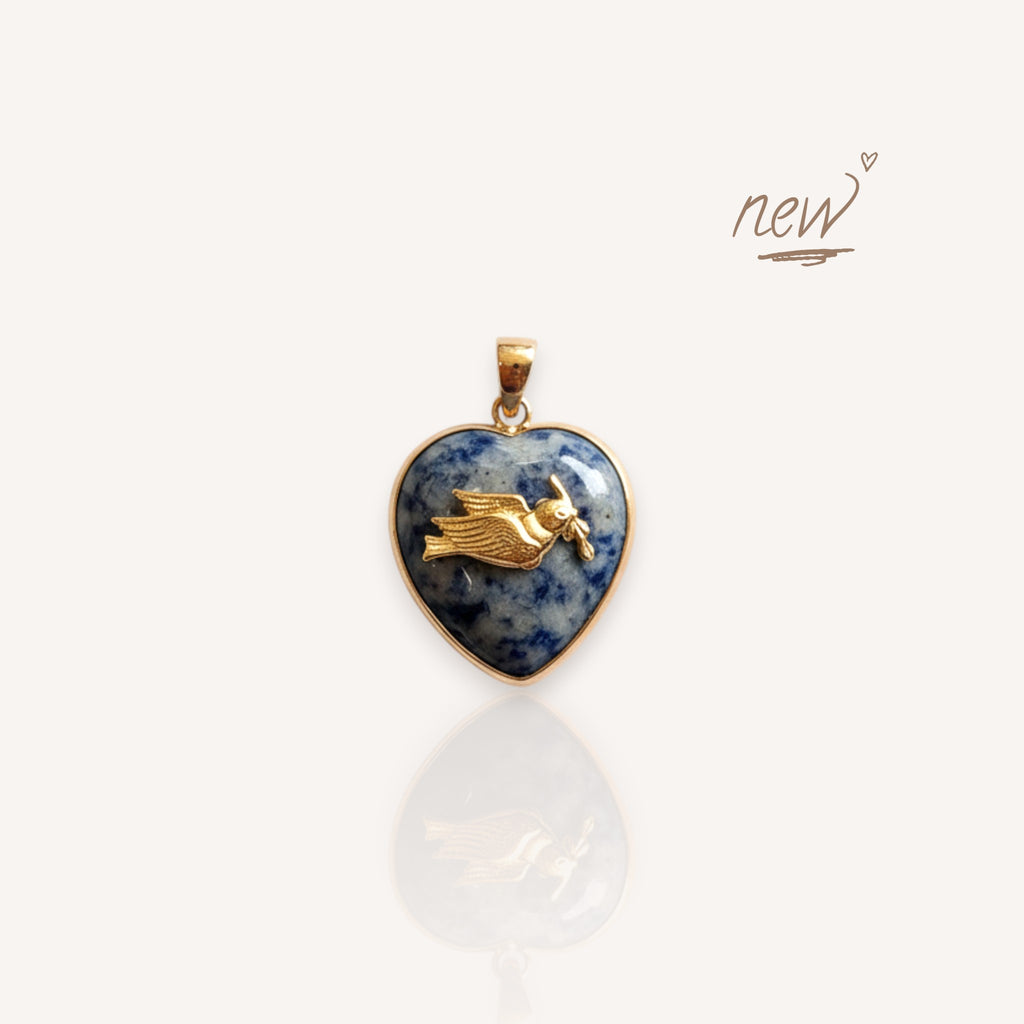 Front view of The Eastern Messenger pendant featuring a speckled blue spot jade heart with a brass dove.