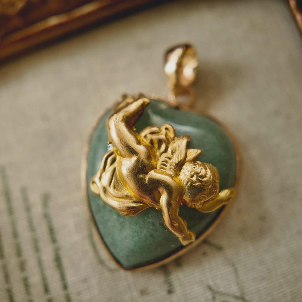 Close-up detail of the vintage brass cherub figure in a tumbling pose on a natural stone background.