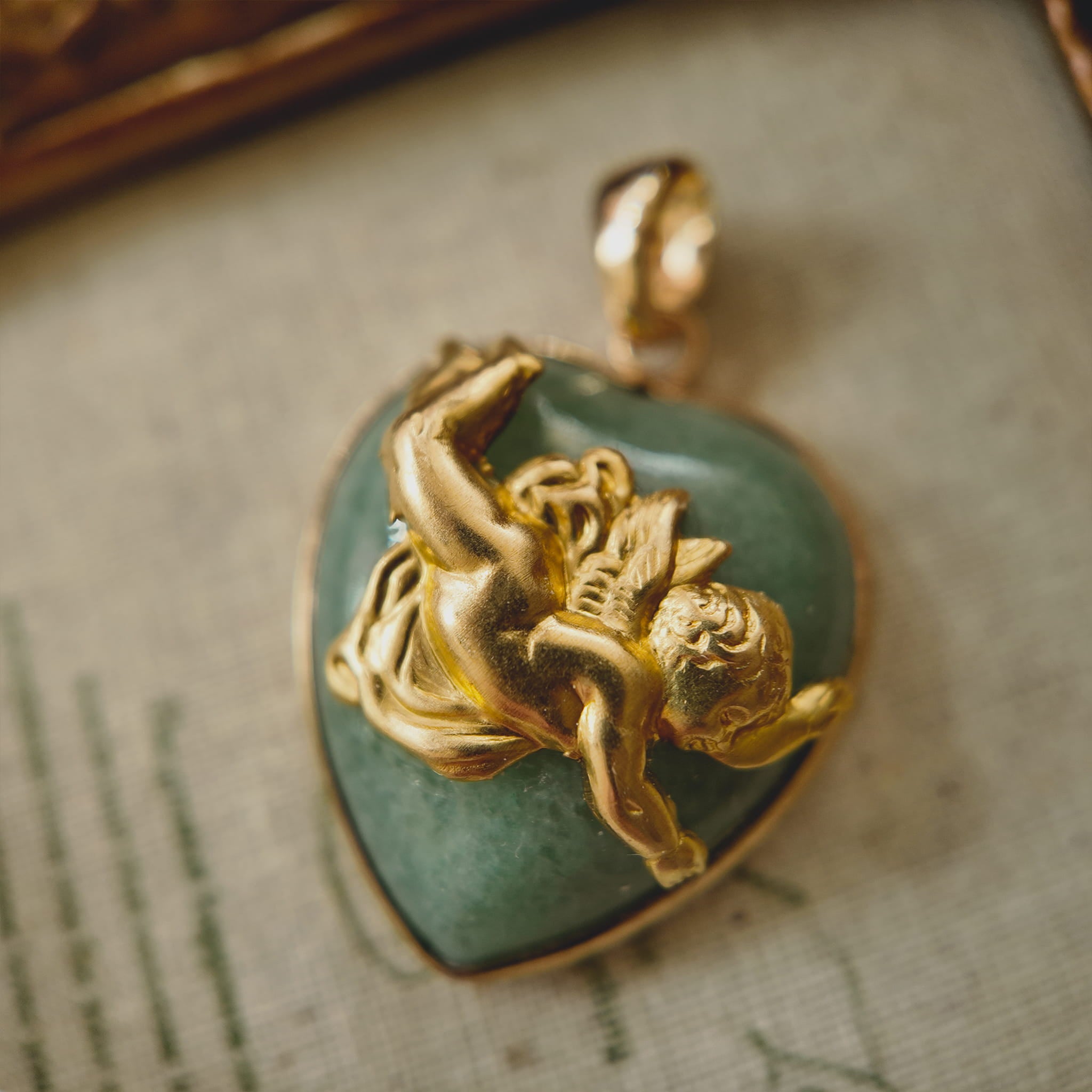 Close-up detail of the vintage brass cherub figure in a tumbling pose on a natural stone background.