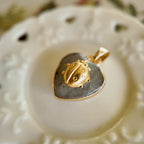 Close-up detail of the micro-miniature vintage brass ladybug resting quietly on the stone surface.