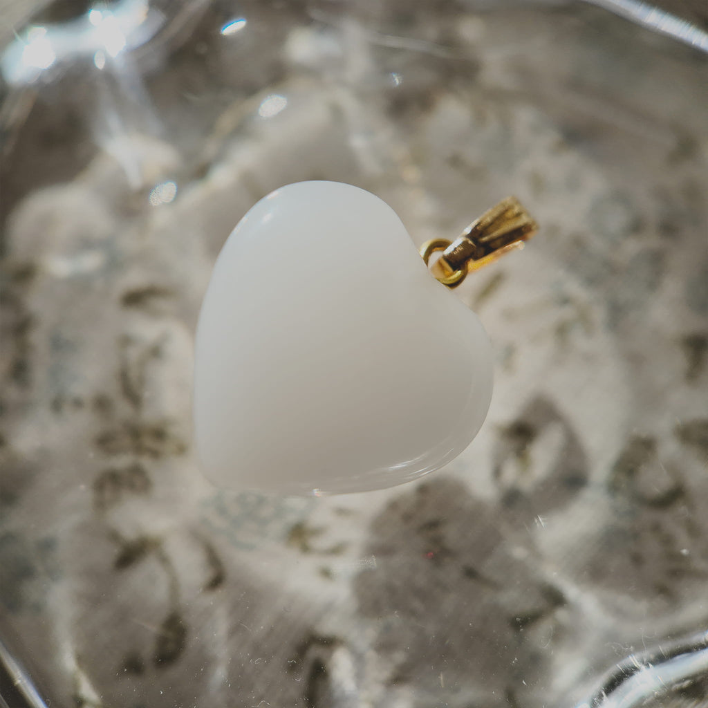 Texture detail of vintage Milk Glass, showing its opaque, creamy white hue and smooth touch, resembling white coral or a polished shell.