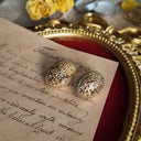 The 1928 Jewelry "Maiden's Shield" earrings worn to showcase their elegant 1.15-inch length and their identity as a piece of "secret armor" for the modern heroine.