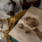 A close-up of the Vendôme couture brooch, showcasing the intricate, hand-woven gold-tone threads and the dramatic, cascading tassel design.