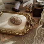 The "WW" brooch styled next to a photo of Wallis Simpson to emphasize its historical significance as a symbol of the 20th century's greatest royal love story.