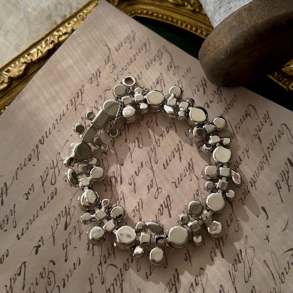 A close-up of the authentic "WEISS" signature on the clasp, also honestly showing the visible scuffs and wear on the back of the vintage bracelet.