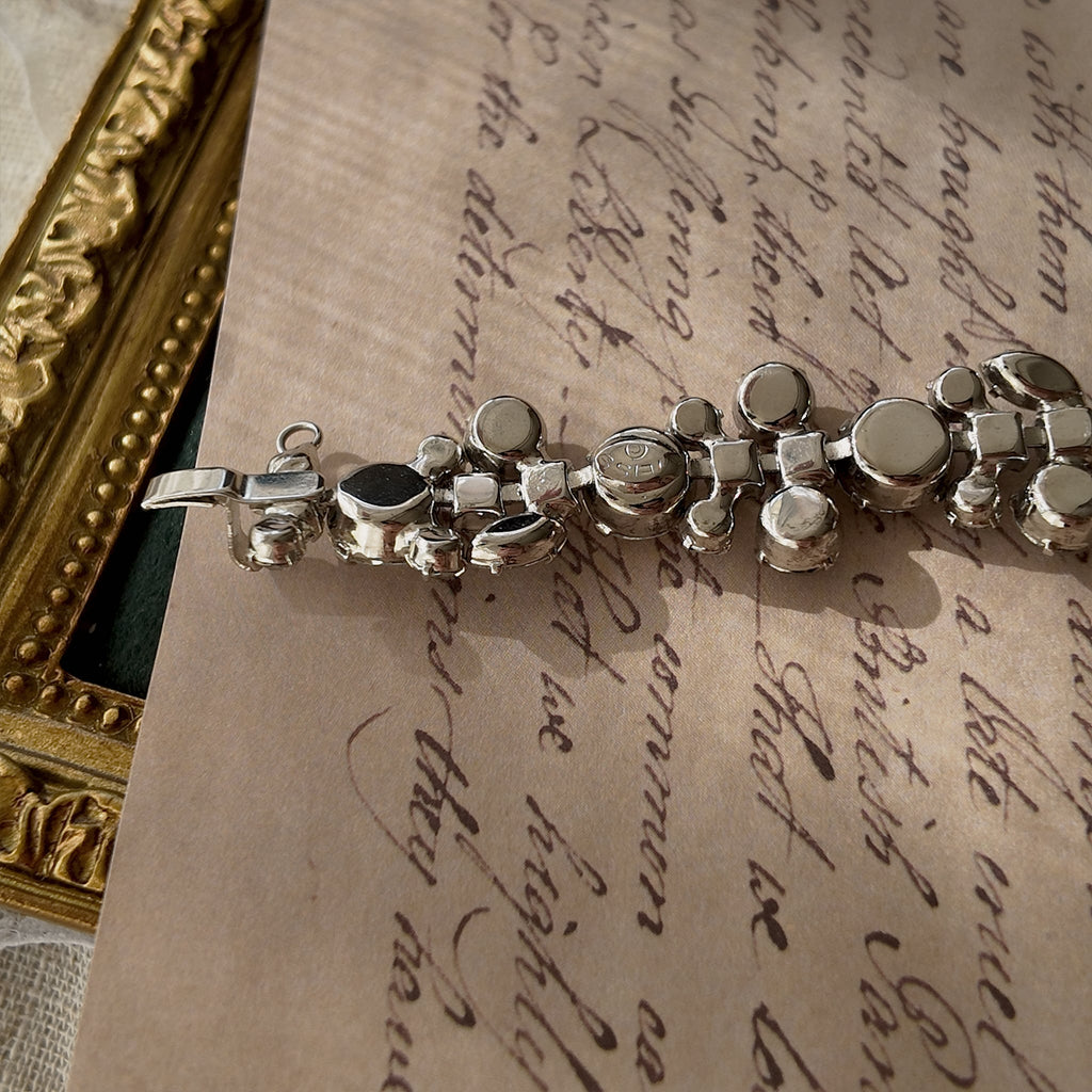 A close-up of the authentic "WEISS" signature on the clasp, also honestly showing the visible scuffs and wear on the back of the vintage bracelet.