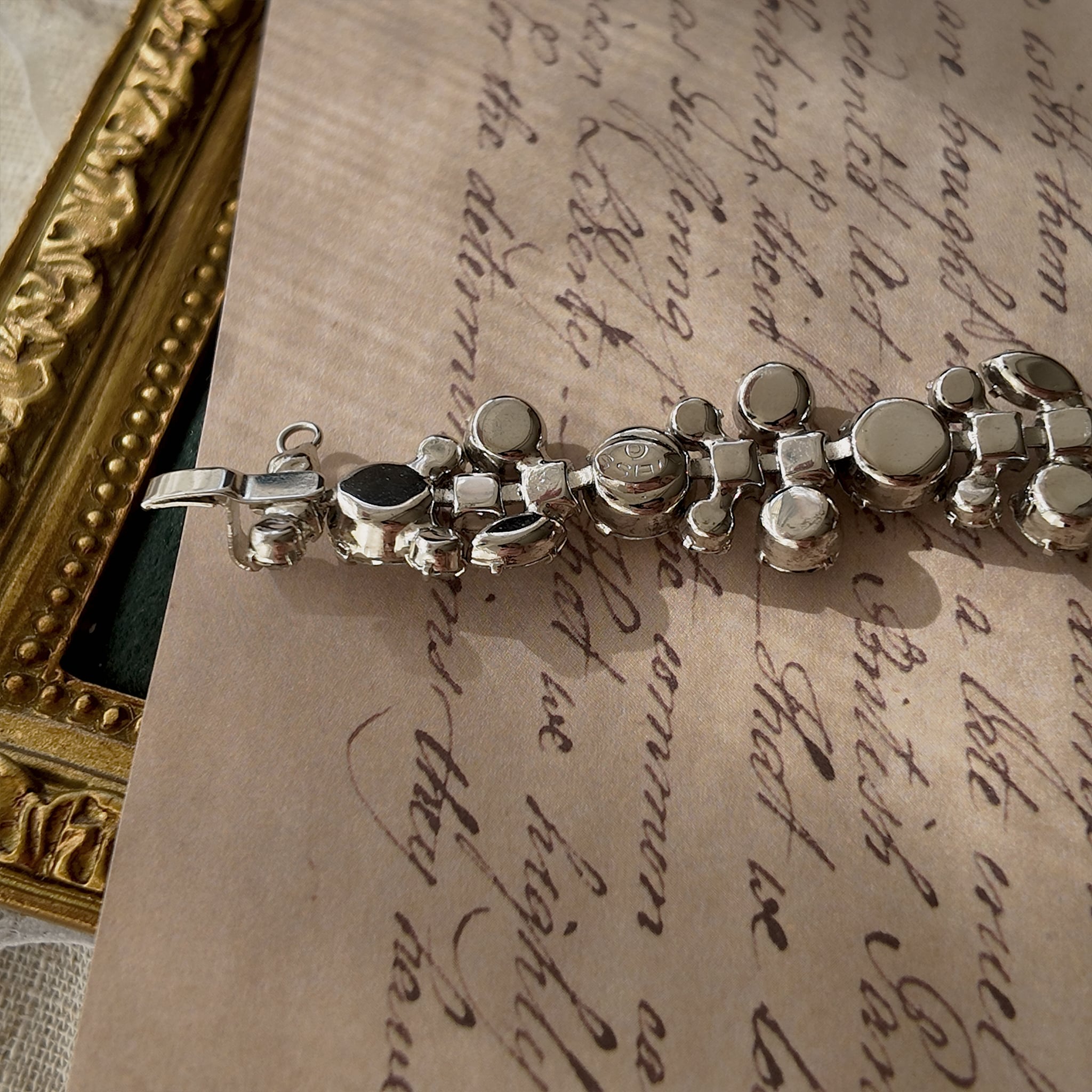 A close-up of the authentic "WEISS" signature on the clasp, also honestly showing the visible scuffs and wear on the back of the vintage bracelet.